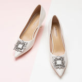 Step into sophistication with these white pumps featuring crystal embellishments and a stylish buckle, perfect for a polished and refined look.