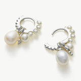 Pearl Huggie Hoops in a moonlit silver hue, delicately adorned with pearls to bring a subtle and enchanting glow to your ears