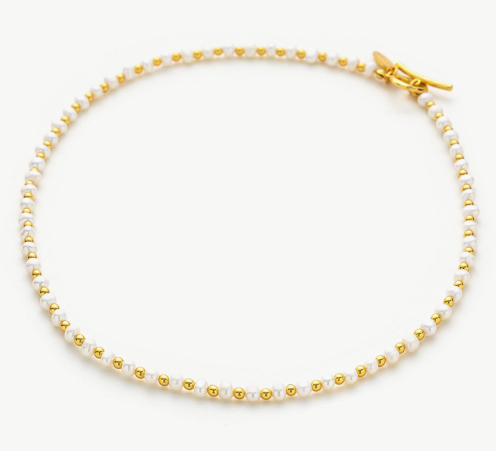 Gold Pearl Beaded Necklace, a radiant pearl charm accompanied by gleaming gold accents, capturing the essence of luxury and creating a stylish and timeless accessory.