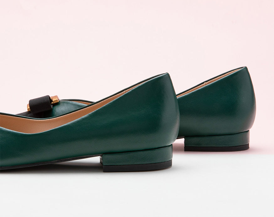 Classic dark green leather flats featuring decorative details