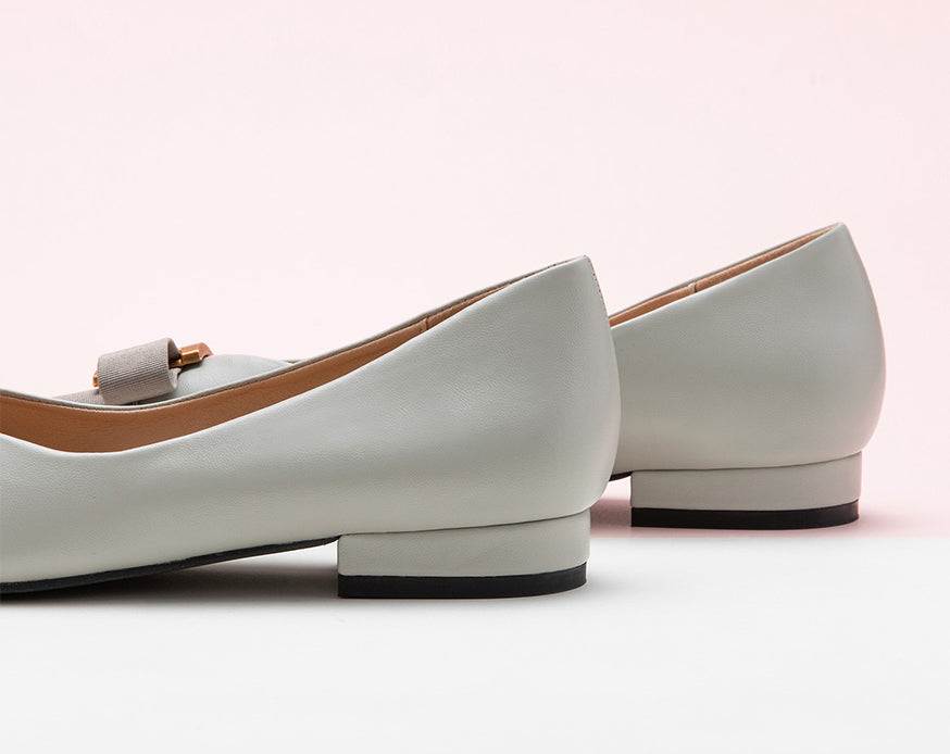Classic grey leather flats featuring decorative details