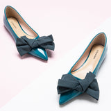 Chic blue Off-Center Flats adorned with a delicate bow, exuding style and grace.