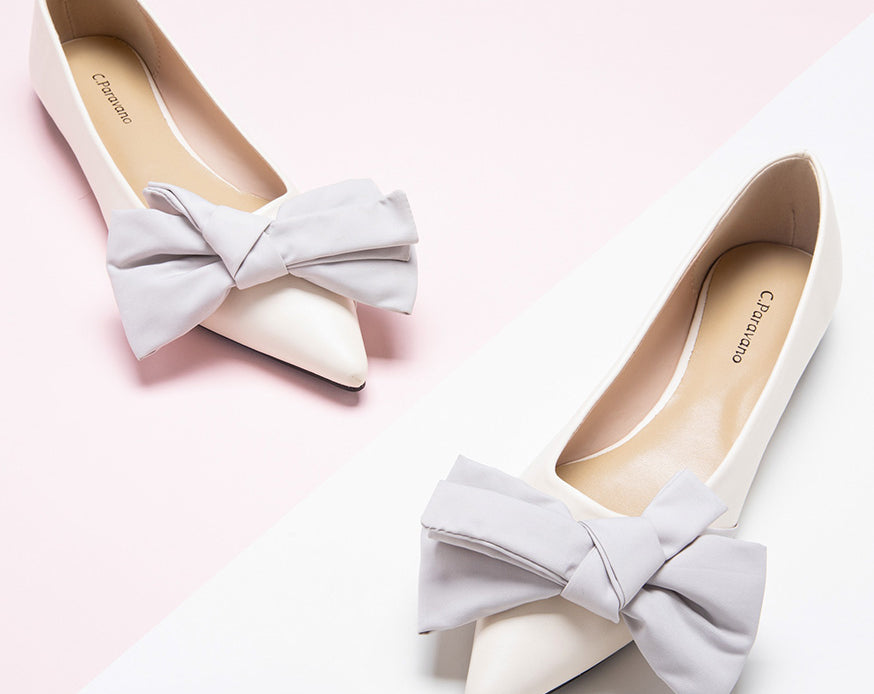 Chic ivory Off-Center Flats adorned with a delicate bow, exuding style and grace
