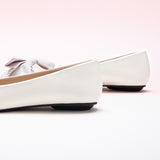 Embrace classic and chic style with these ivory off-center flats, featuring a charming bow embellishment for a timeless and versatile look.