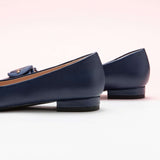 Embrace versatile and stylish flair with these navy pointed toe flats, featuring a charming C buckle detail for a timeless look