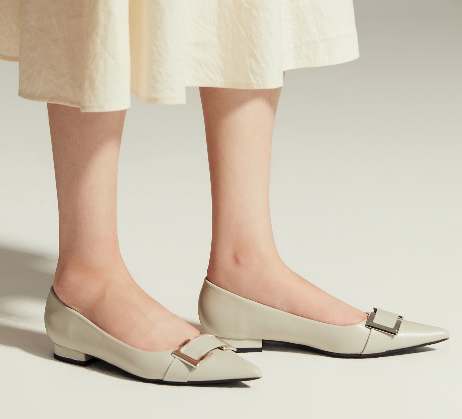 Grey Flats with a stylish Metal Buckle and Pointed Toe, perfect for a confident and fashionable look in any urban setting.