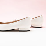 White Trapezoidal Buckle Flats, perfect for a confident and fashionable look in any urban setting.