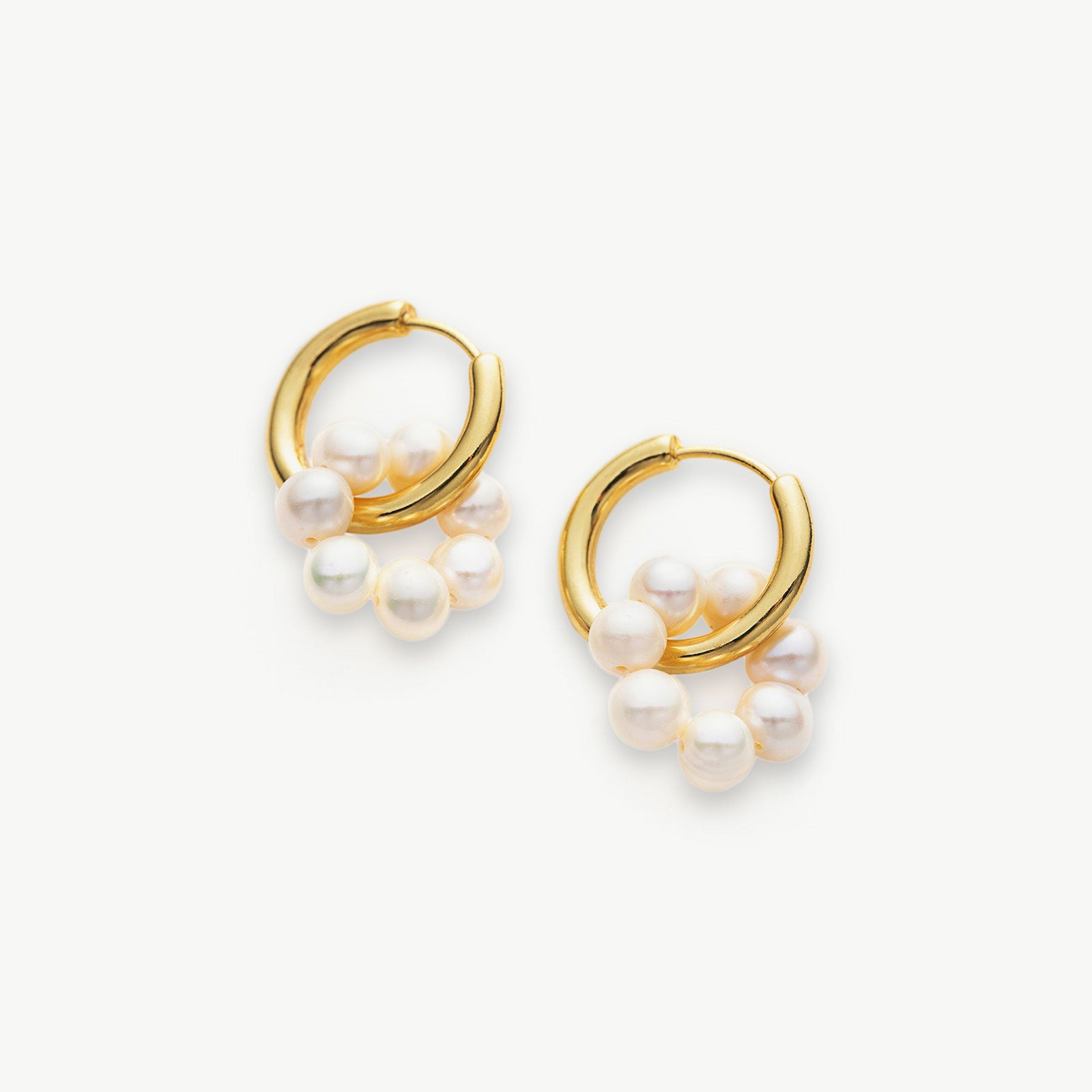 Tunnel Hoop Earrings adorned with delicate seed pearls, an elegant and timeless accessory that adds a touch of sophistication to your ensemble