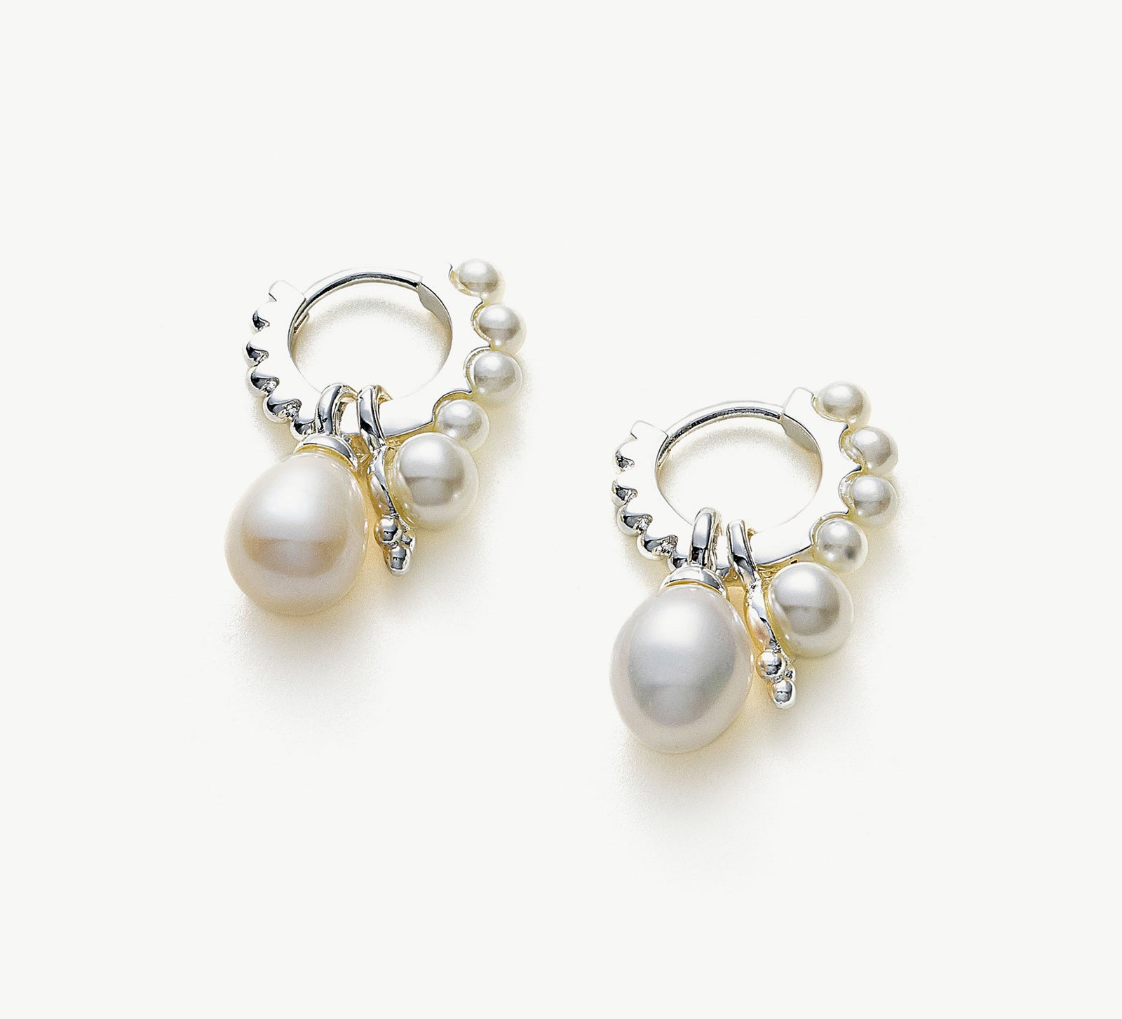 Pearl Huggie Hoops in Silver, a sleek and stylish accessory that embraces your ears with the timeless elegance of pearls against a silver backdrop