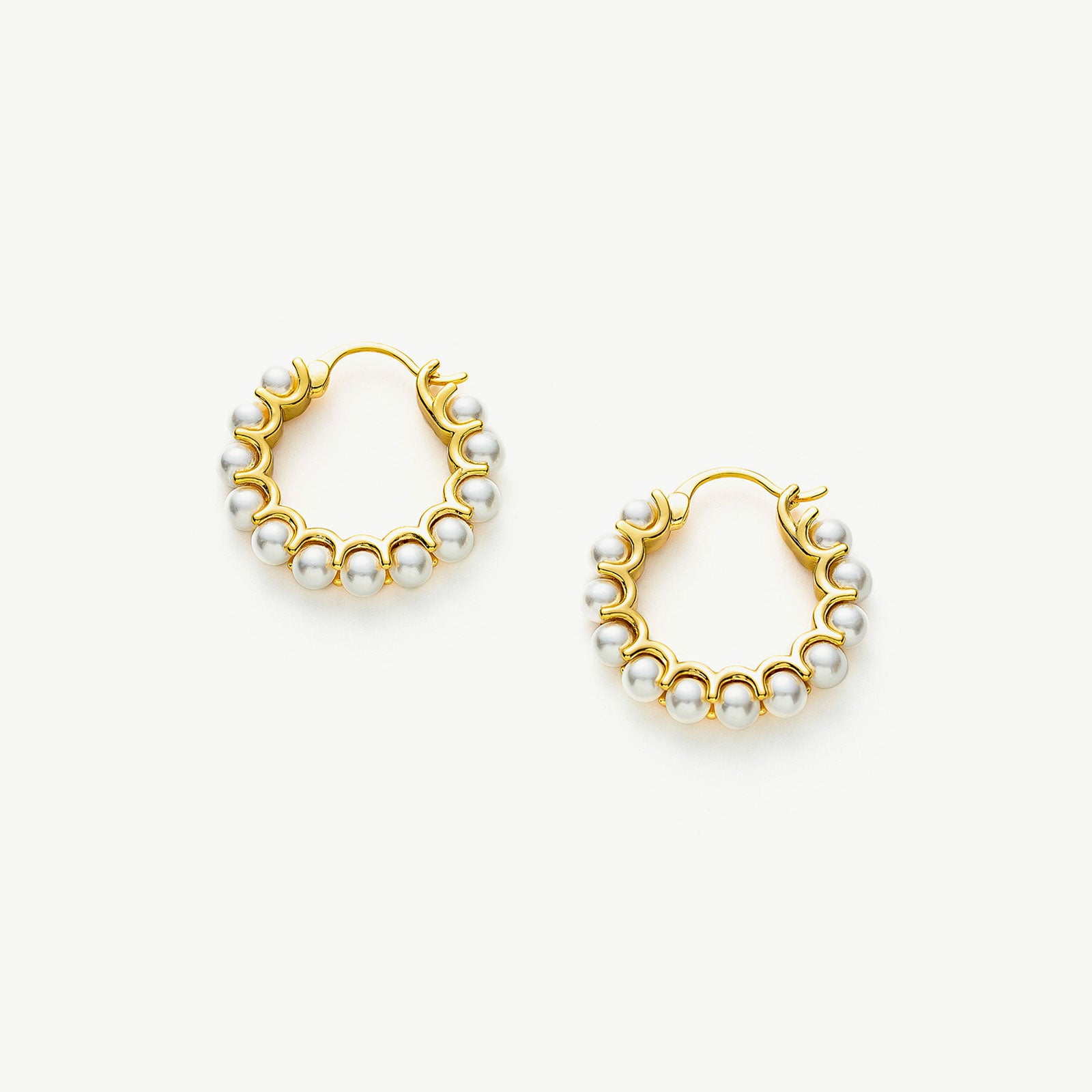 Medium Pearl Huggie Earrings, featuring a medium-sized design that gently hugs the ear, these earrings exude elegance with their lustrous pearl accents