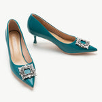 Peacock blue leather pumps adorned with crystal buckle embellishment