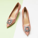 Pink leather pumps featuring a dazzling crystal buckle detail