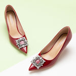 Elegant red high heels adorned with a sparkling crystal buckle.