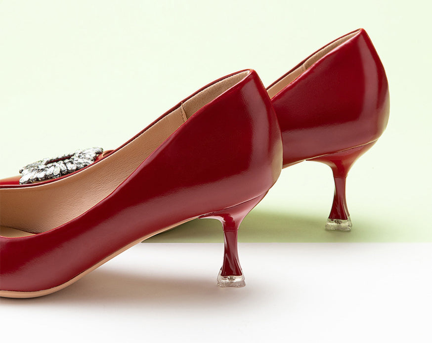 "Chic and luxurious red pumps enhanced by a crystal buckle