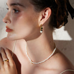 Pearl Drop Earrings in Gold featuring classic pearl adornments and golden accents, these earrings offer a versatile and stylish accessory that complements any outfit with grace.