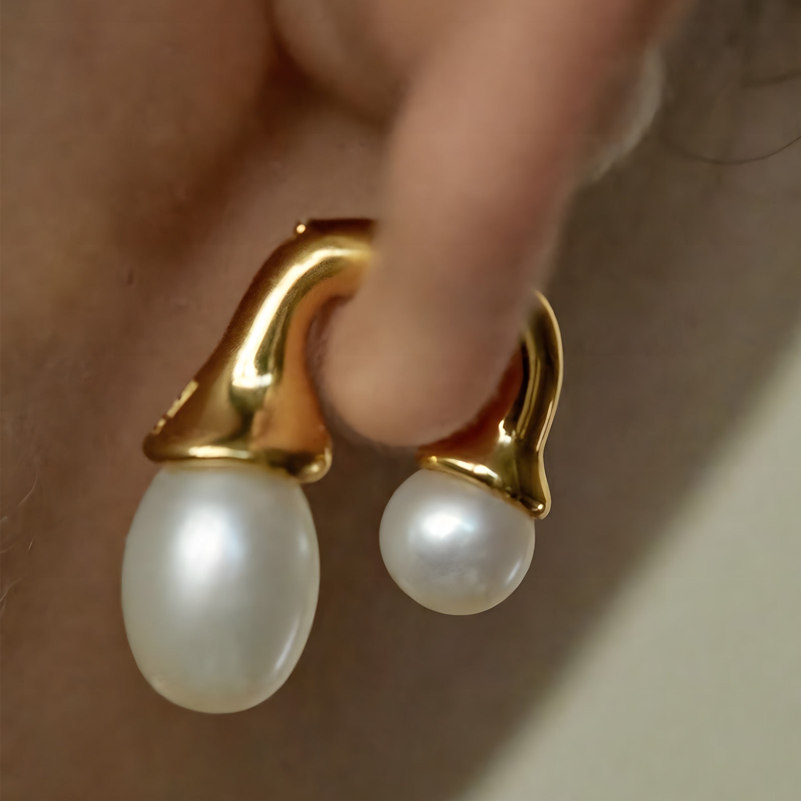 Gold Earrings adorned with two pearls, a chic and stylish choice for adding a touch of sophistication to your ensemble