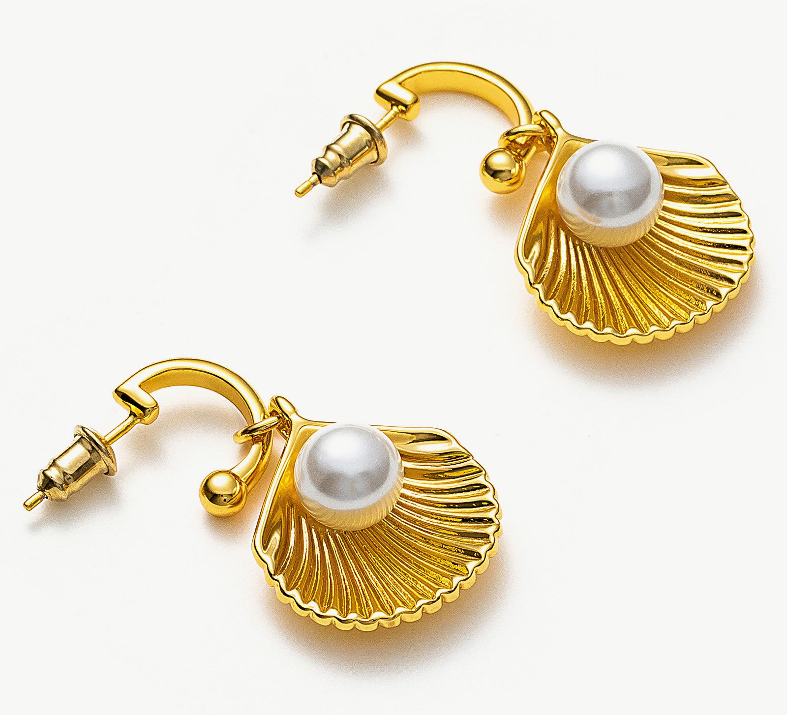Pearl Shell Hoops, embodying coastal chic with pearls embraced by sculpted shell accents, these earrings offer a stylish and trendy accessory reminiscent of the beachside allure