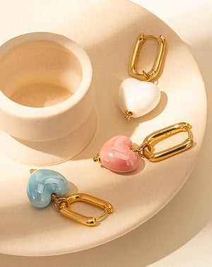    Elegant-gold-earrings-showcasing-ovate-shape-and-white-heart-design_-a-luxurious-accessory-choice