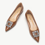 Brown leather flats adorned with stylish embellishments for a touch of elegance