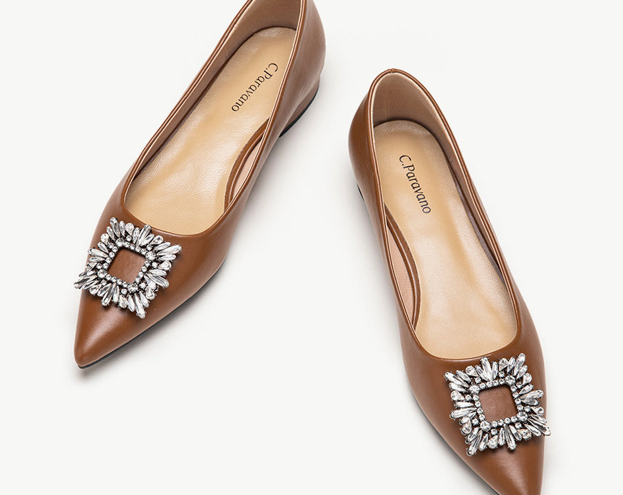 Brown leather flats adorned with stylish embellishments for a touch of elegance