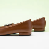 Classic brown leather flats featuring decorative details