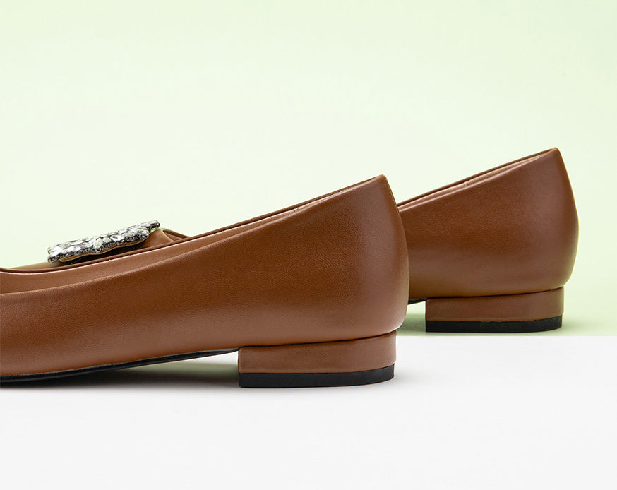 Classic brown leather flats featuring decorative details