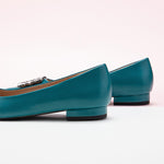 Classic peacock blue leather flats featuring decorative details.
