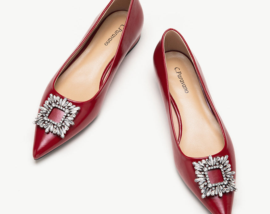 Red leather flats adorned with stylish embellishments for a touch of elegance