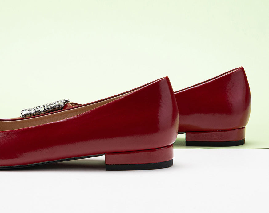 Classic red leather flats featuring decorative details