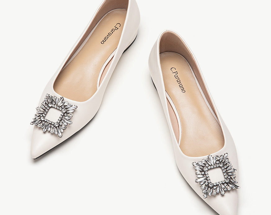 White leather flats adorned with stylish embellishments for a touch of elegance