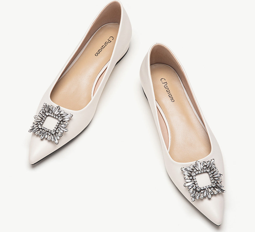 White leather flats adorned with stylish embellishments for a touch of elegance
