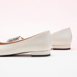 Classic white leather flats featuring decorative details