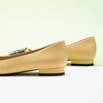 Classic yellow leather flats featuring decorative details