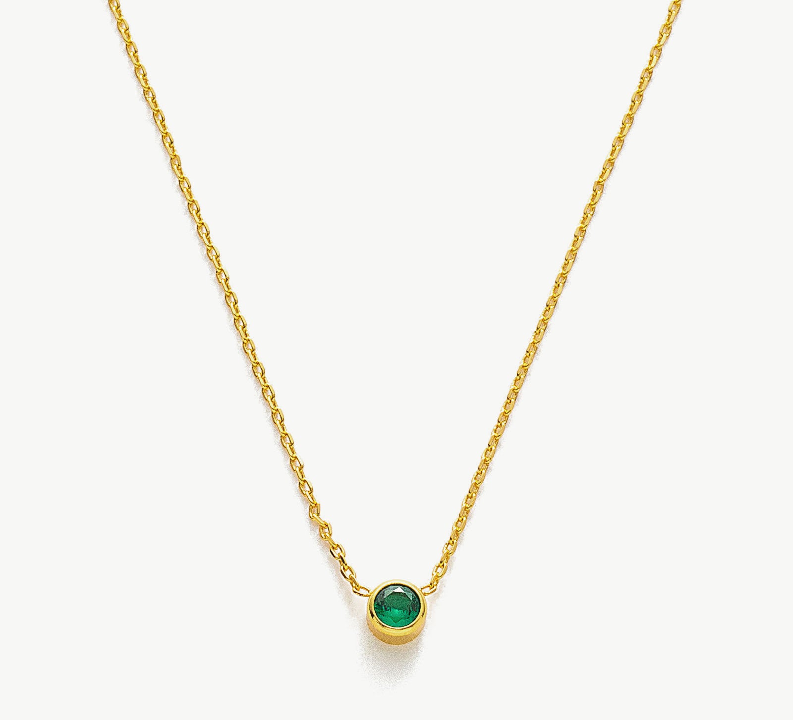 Gold Emerald Crystal Pendant Necklace, showcasing a vibrant emerald green crystal pendant on a delicate gold chain, adding a touch of elegance to your style.