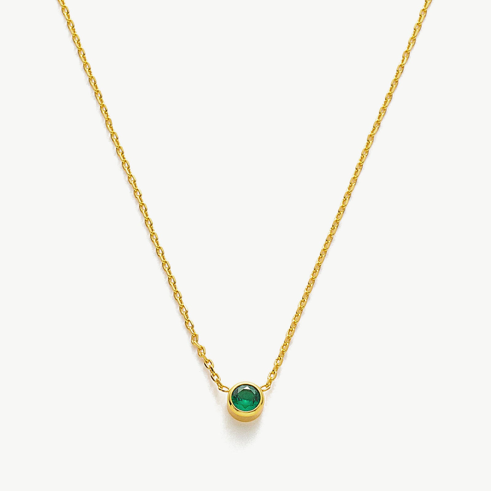Gold Emerald Crystal Pendant Necklace, showcasing a vibrant emerald green crystal pendant on a delicate gold chain, adding a touch of elegance to your style.