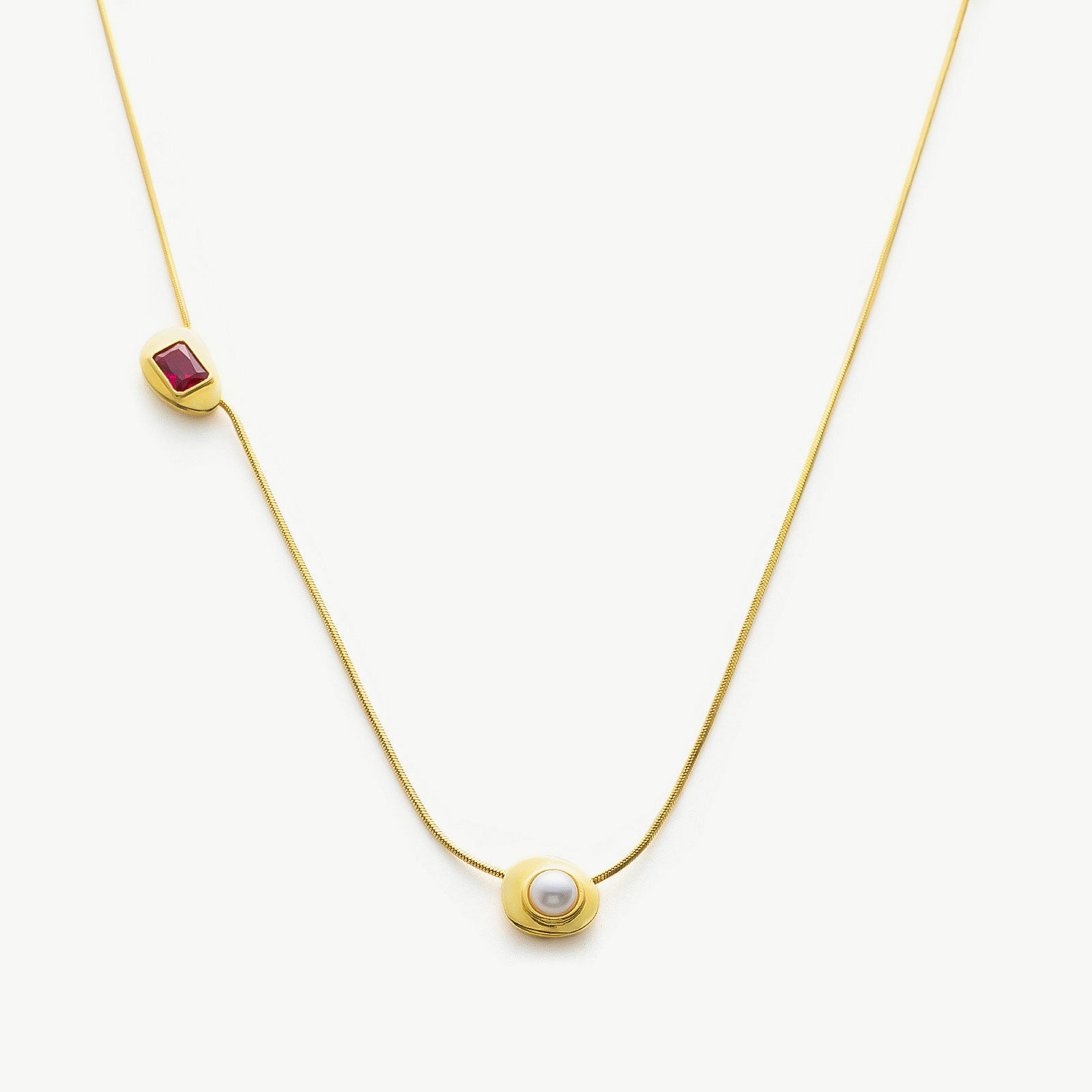 Gold Crystal Drop Necklace with a captivating ruby crystal pendant, showcasing a radiant and elegant design on a golden chain, adding a touch of glamour and sophistication to your ensemble.