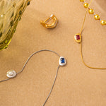 Gold Crystal Drop Necklace, symbolizing eternal beauty, this necklace features a crystal drop pendant in a captivating ruby hue, suspended from a golden chain, expressing a sense of enduring style and grace