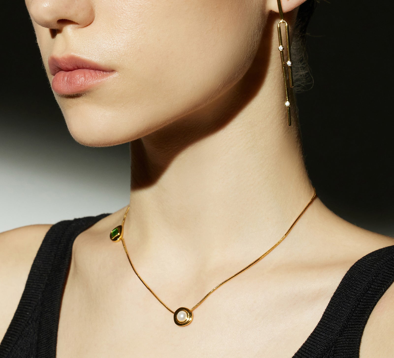 Gold Crystal Drop Necklace in Emerald, an enchanting emerald glow that radiates elegance, featuring a crystal drop pendant in a vibrant green hue, creating a timeless and stylish accessory