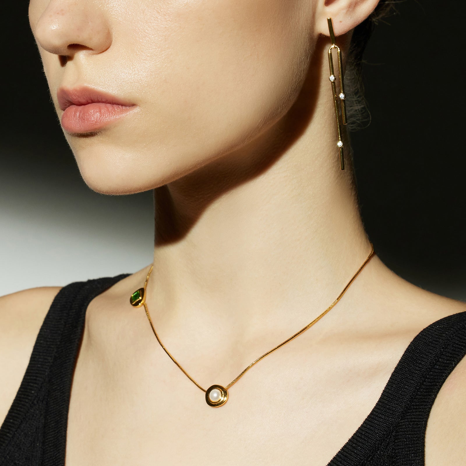 Gold Crystal Drop Necklace in Emerald, an enchanting emerald glow that radiates elegance, featuring a crystal drop pendant in a vibrant green hue, creating a timeless and stylish accessory