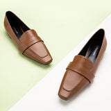 Stylish brown loafers in an urban setting.