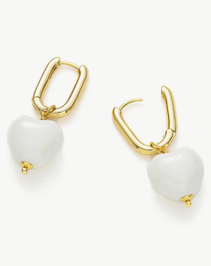     Stylish-gold-ovate-earrings-with-white-heart-shaped-pendants_-offering-a-unique-and-contemporary-look