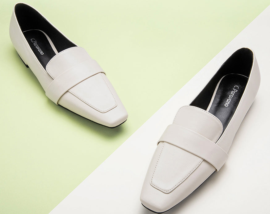 Stylish white loafers in an urban setting.