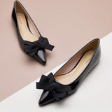 Sophisticated black Point Toe Flats in glossy patent leather, a timeless classic.