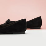 Black suede flats designed for a fashionable and comfortable look.